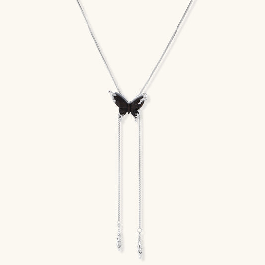 Wooden butterfly pendant necklace with cascading silver-toned chains on adjustable chain, available in amber and black.