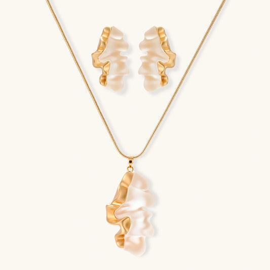 Sculptural gold-toned jewelry set featuring wavy organic earrings and matching necklace pendant with translucent resin accents.